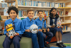 A photo of four students from St Anne’s Catholic Primary School Strathfield South showcasing their innovative robotic creations
