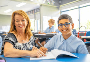 A photo of Marea De Angelis with a beaming student in the classroom at Villa Maria Catholic Primary School Hunters Hill